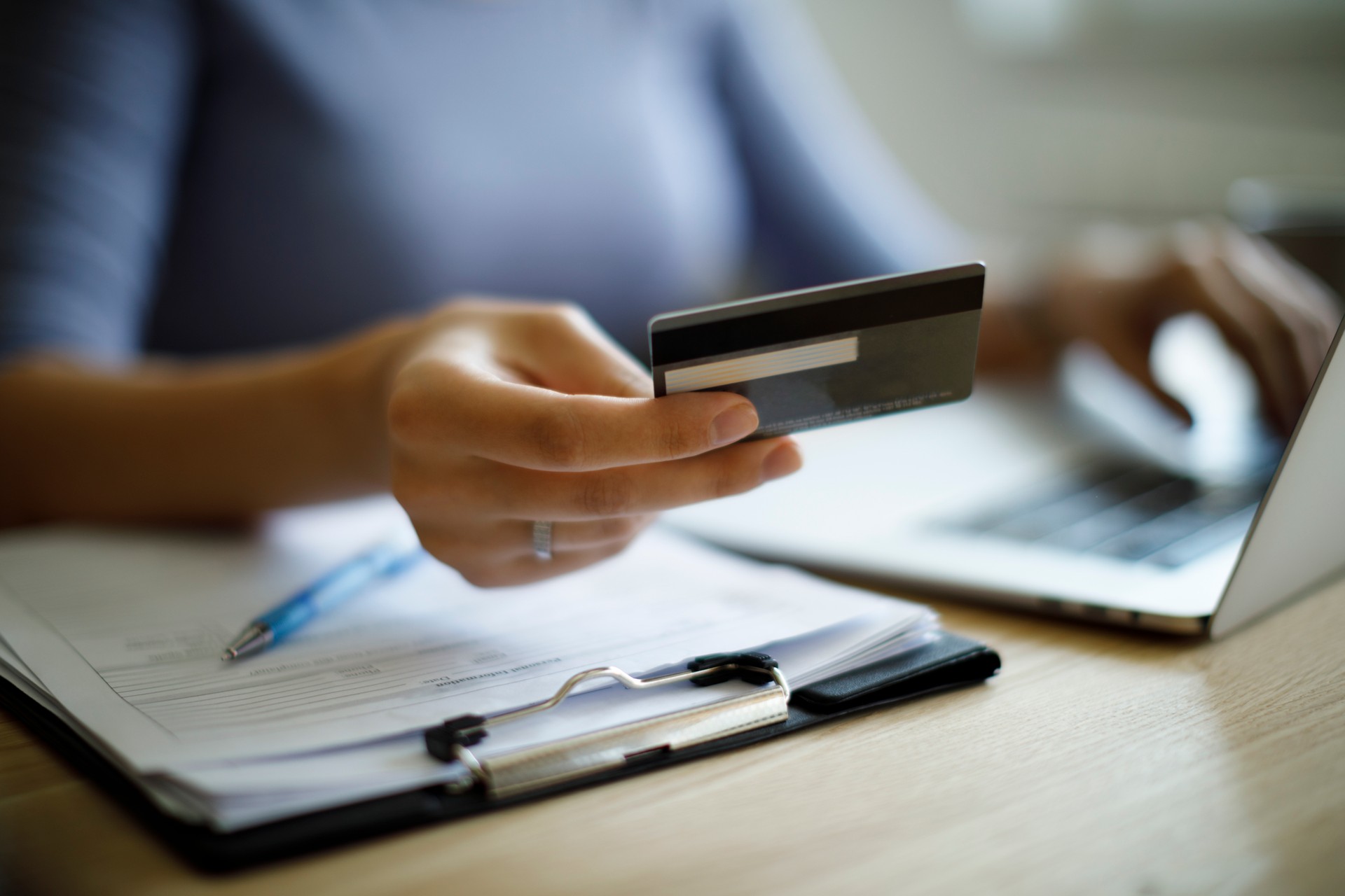 Woman using credit card and laptop to pay bills